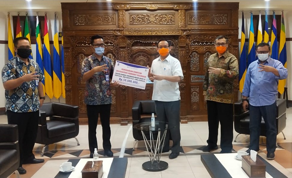 Assistant Managing Director Penerbit Erlangga Rikki L Tobing menyerahkan bantuan ke UNAIR dan diterima langsung oleh Rektor Prof M Nasih (dok Erlangga)